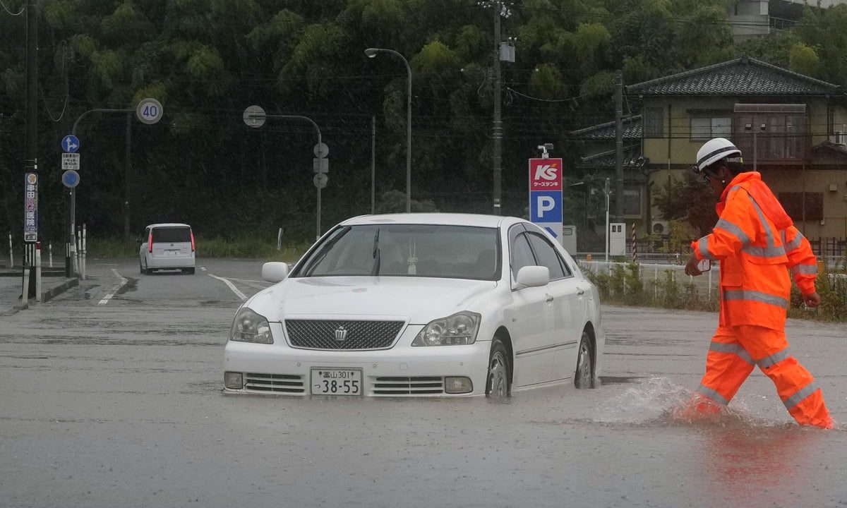 Heavy rain and flooding in north-central Japan strands people and vehicles