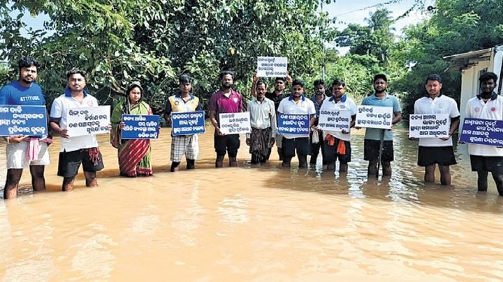 Youths stand in knee-deep floodwater to protest official apathy at  Kendrapara’s Aul block
