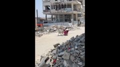 Children take cover behind shopping cart during Israeli drone fire