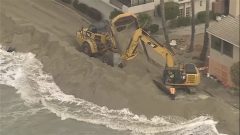 Waves crash into homes as excavators try to protect California properties