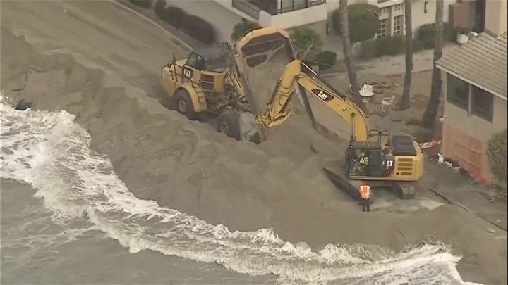 Waves crash into homes as excavators try to protect California properties